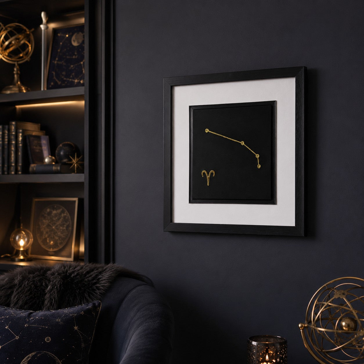 Angled wall view of Aries constellation framed wall art in gold, styled in a moody astrology-inspired room with dark decor, books, candlelight and celestial accents.
