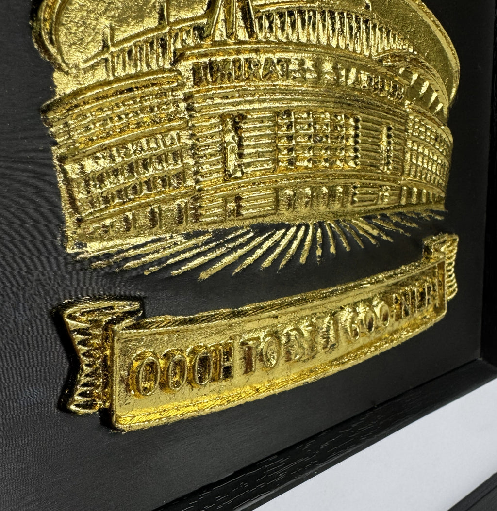 close up gold 3D relief wall art of Arsenal Emirates Stadium on black background.