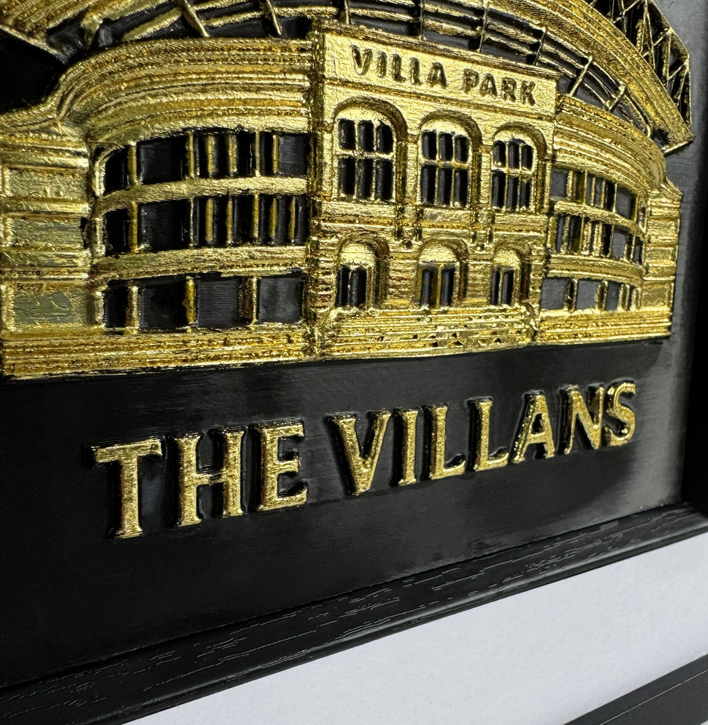 gold 3D relief wall art close up of Aston Villa Villa Park stadium on black background.