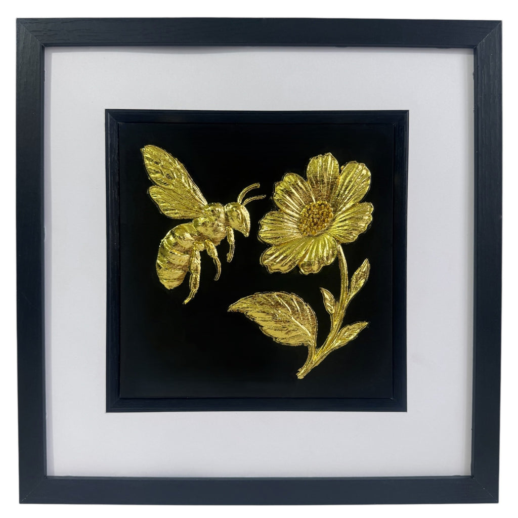 Gold bee and flower wall art on black background with white mount