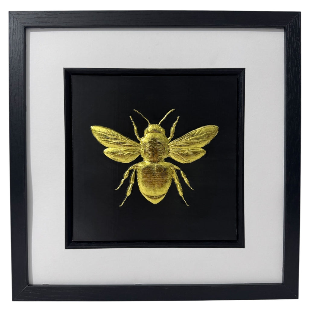 Front-facing gold leaf bumble bee wall art with black background and white mount
