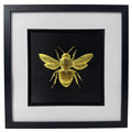 Front-facing gold leaf bumble bee wall art with black background and white mount