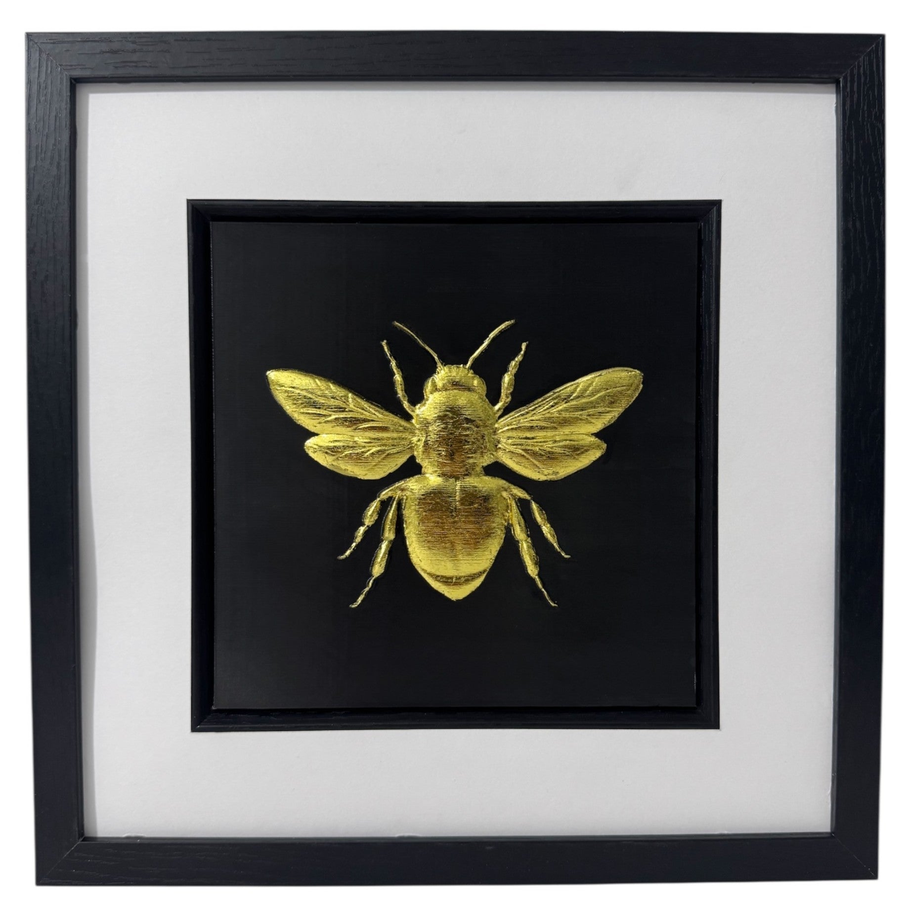Front-facing gold leaf bumble bee wall art with black background and white mount