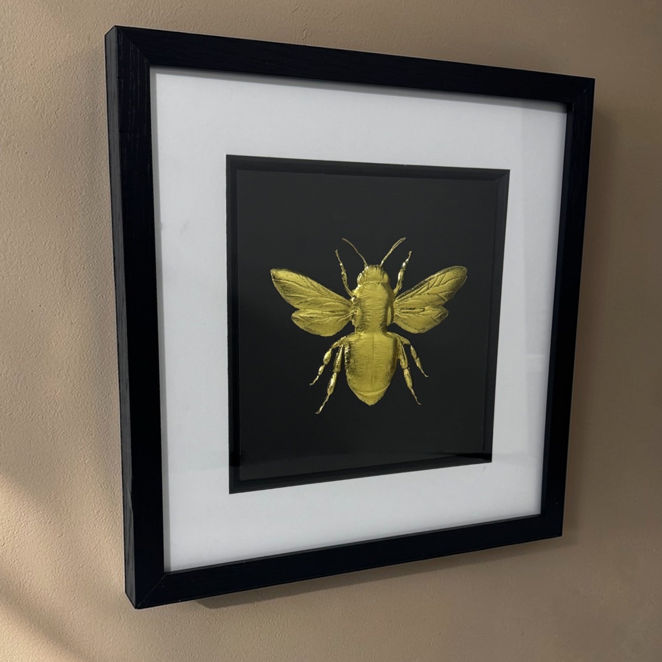 Angled wall-mounted view of bumble bee wall art showing frame depth
