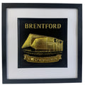 Gold Brentford stadium 3D relief artwork with “BRENTFORD” text and “SING UP FOR THE BEES” banner in black square frame with white mount, front view