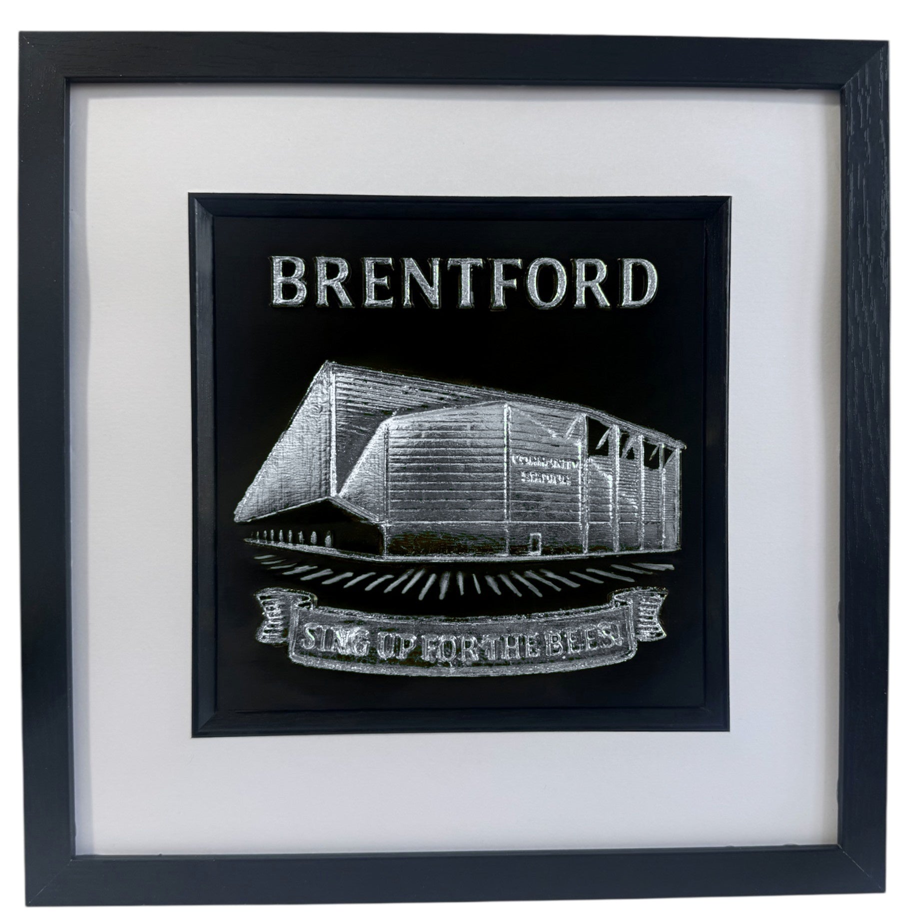Silver Brentford stadium 3D relief artwork with “BRENTFORD” text and “SING UP FOR THE BEES” banner in black square frame with white mount, front view