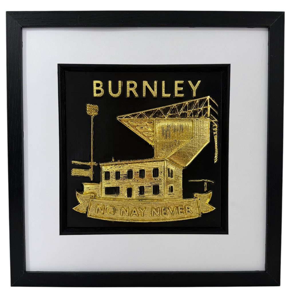 Front view of gold Burnley football club wall decor in a black frame with white mount and black inner surround.