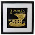 Front view of gold Burnley football club wall decor in a black frame with white mount and black inner surround.