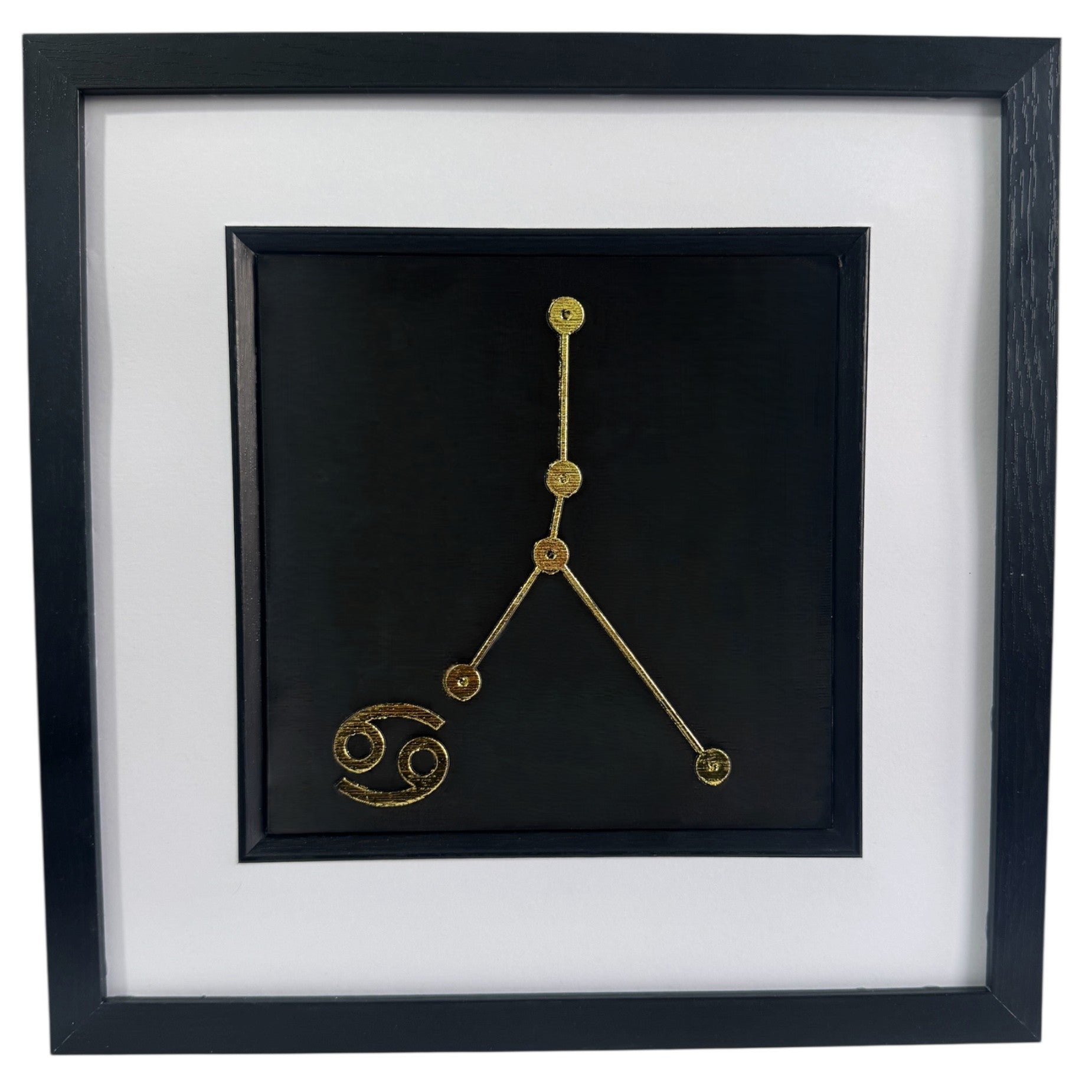 Framed Cancer constellation 3d wall art in gold leaf with star pattern and zodiac symbol, centred on a black background with white mount and black frame