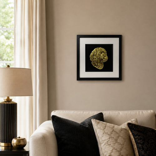 Cavapoo gold leaf framed dog wall art displayed above a cream sofa in a warm neutral living room with black and gold accents.