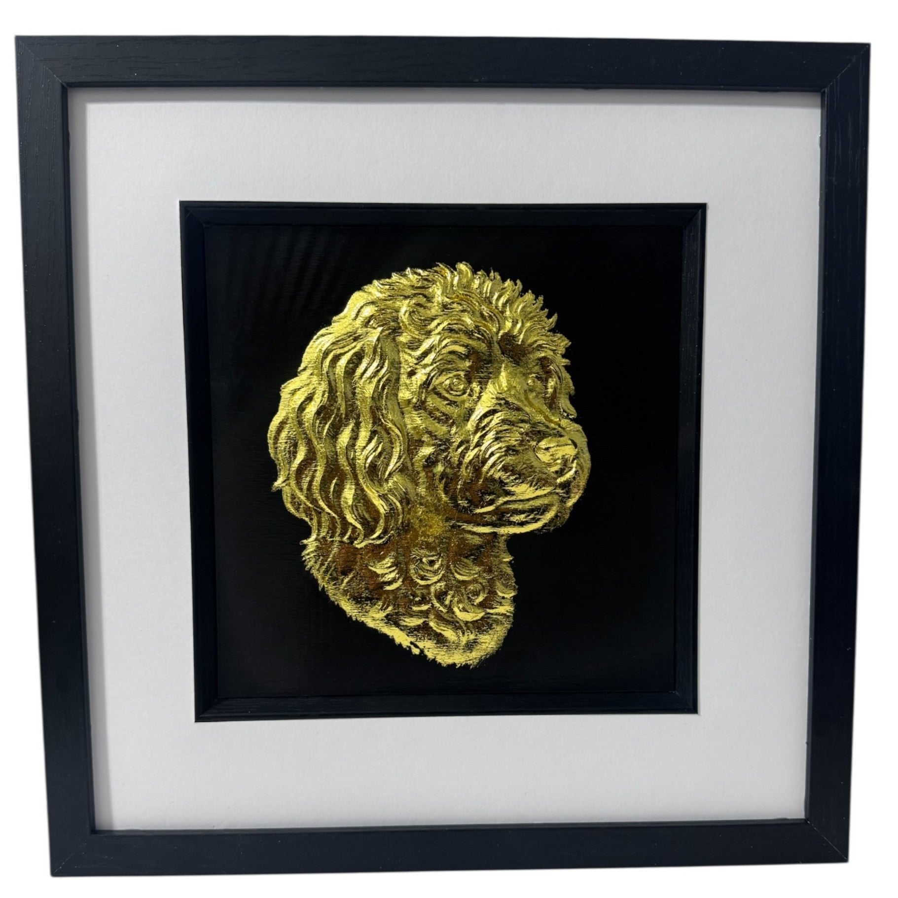 Framed cavapoo wall art with gold relief portrait on a black background, presented in a black frame with white mount on a pure white background