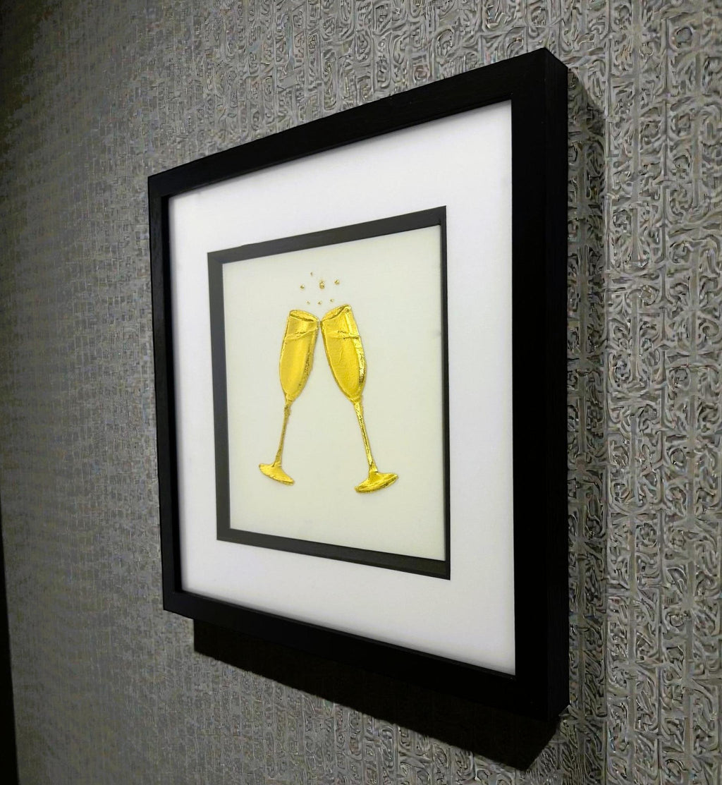 Angled wall-mounted view of champagne glasses wall art framed in black with white mount