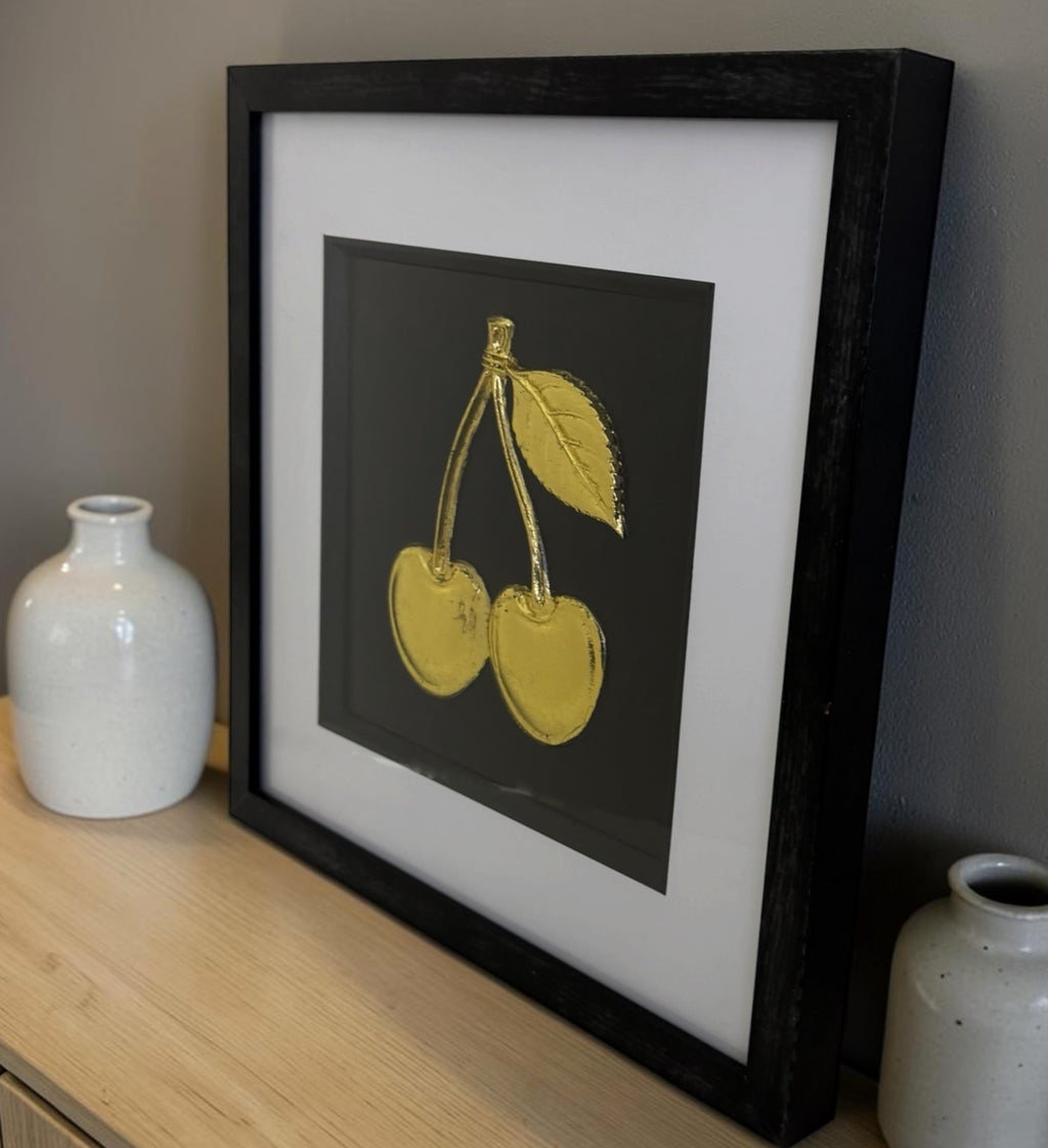 Gold cherry framed 3D artwork styled on a wooden sideboard with neutral ceramic vases.