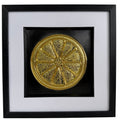 Straight-on Gold orange slice relief artwork with segmented citrus detail, black background and white mount.