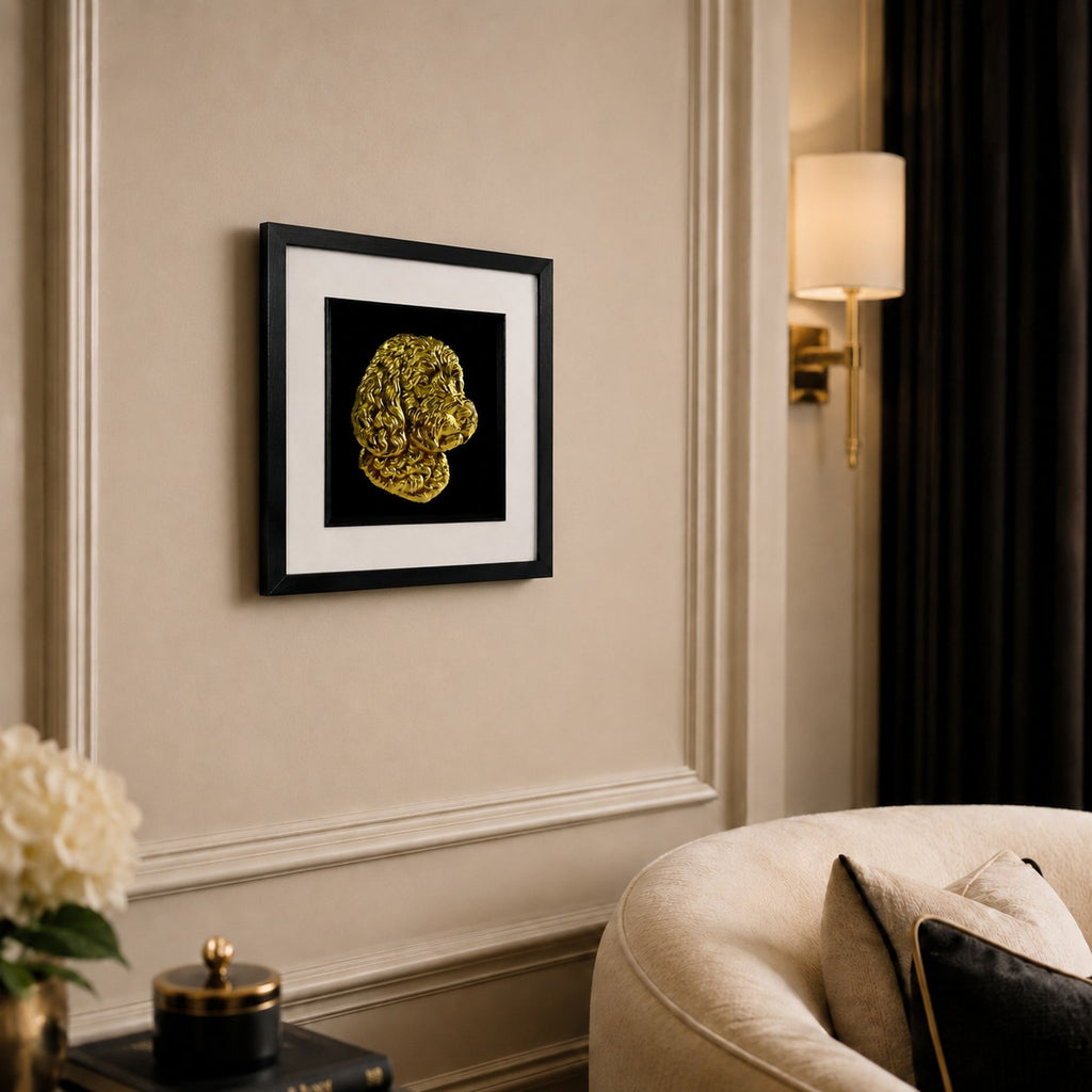 Angled lifestyle view of Cockapoo gold 3D relief dog wall art in a black frame with white mount on a warm neutral wall.