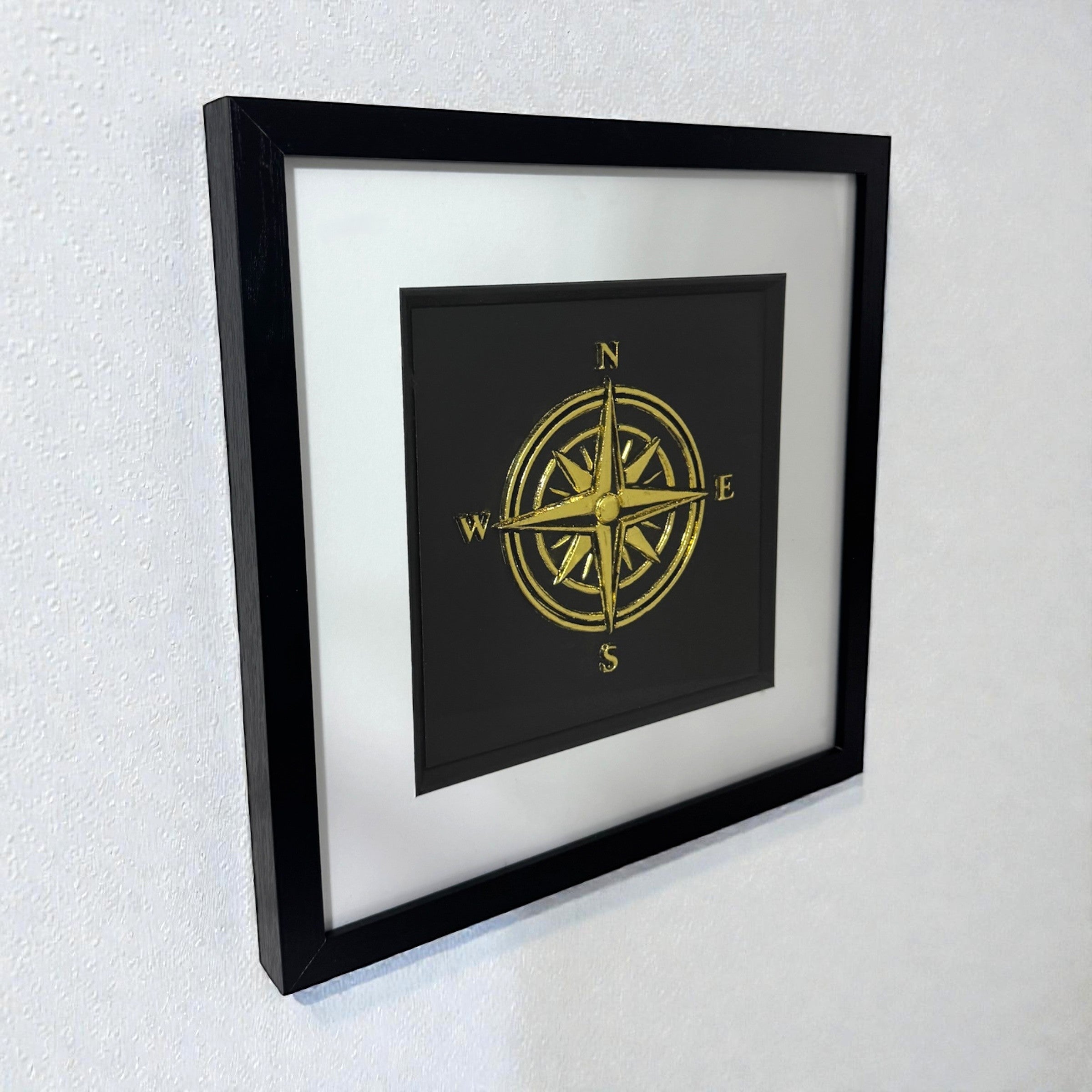 Gold compass wall art displayed on a wall, a calm new job gift with raised relief compass rose design