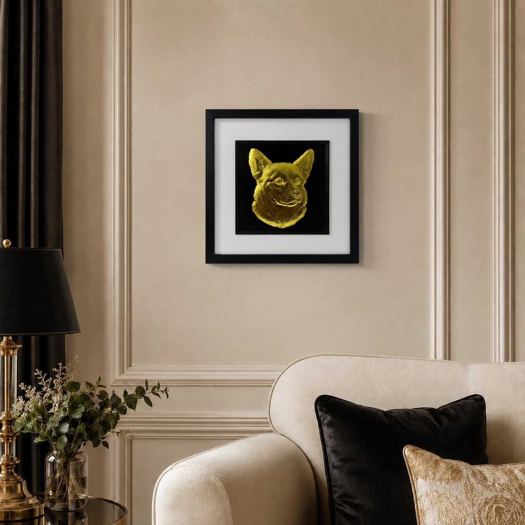 Corgi gold leaf framed dog wall art displayed above a cream sofa in a warm neutral living room with black and gold accents.