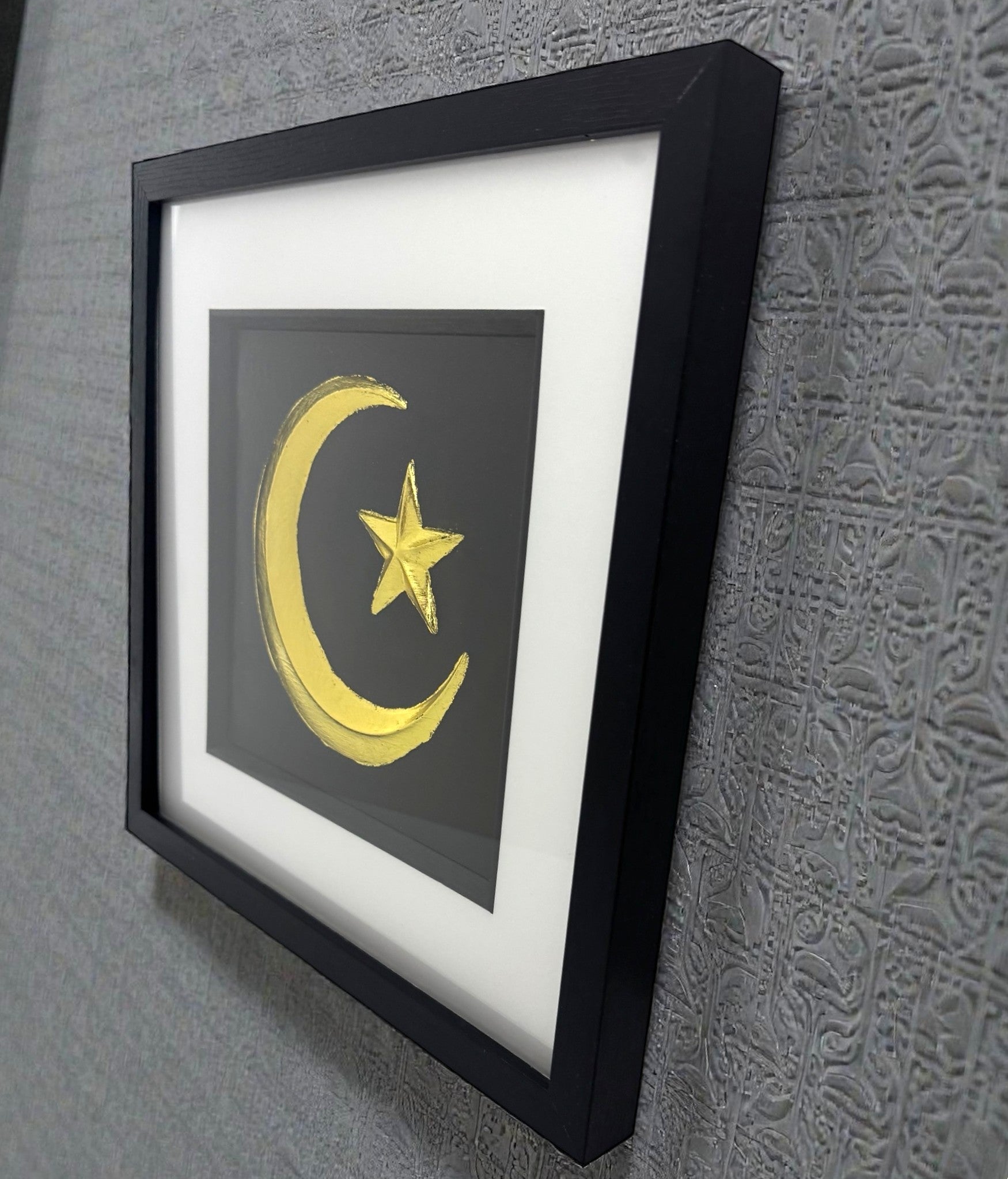 Crescent moon and star framed wall art displayed on wall