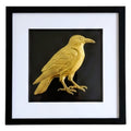 Front-facing gold leaf crow wall art on black background with white mount