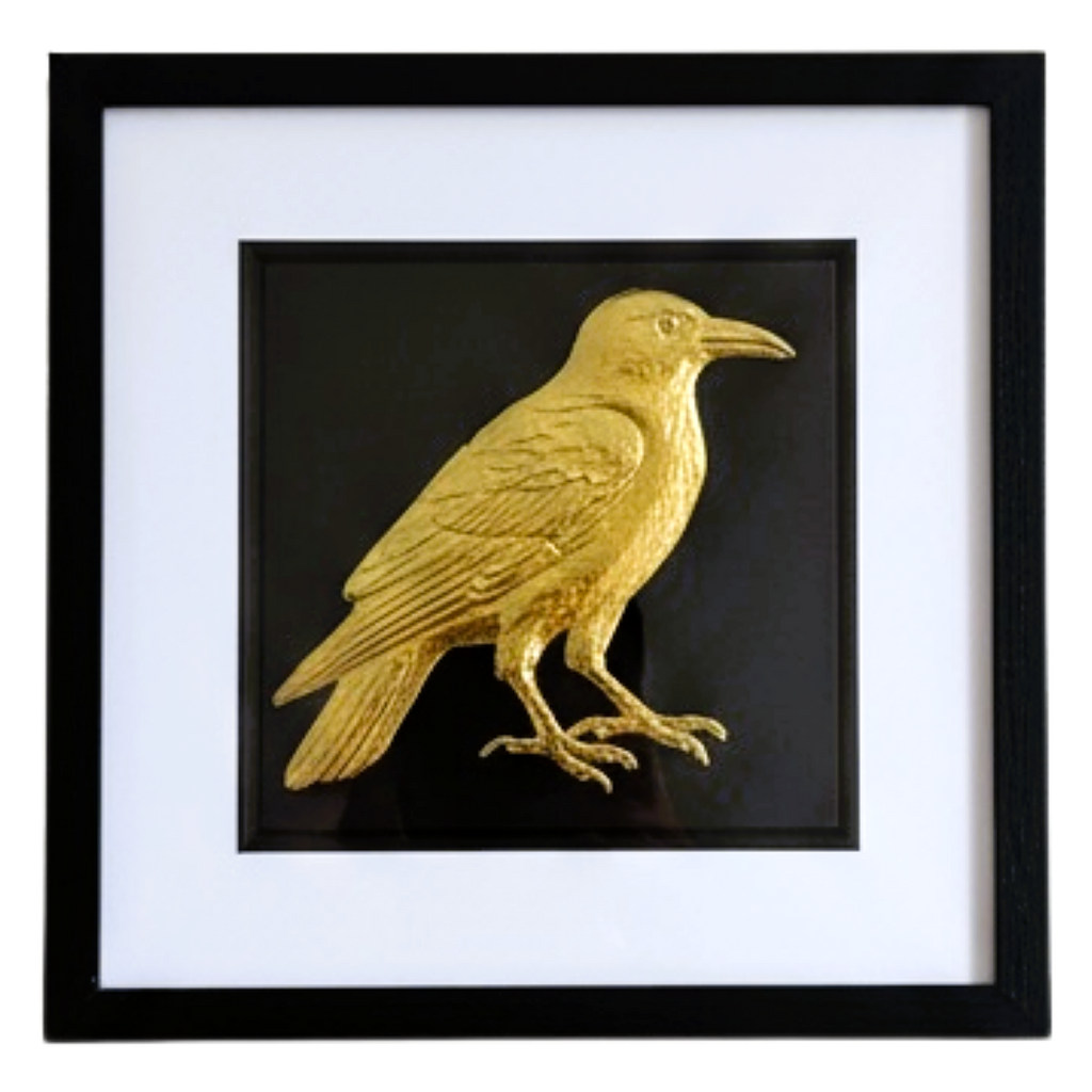 Front-facing gold leaf crow wall art on black background with white mount