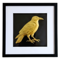 Front-facing gold leaf crow wall art on black background with white mount
