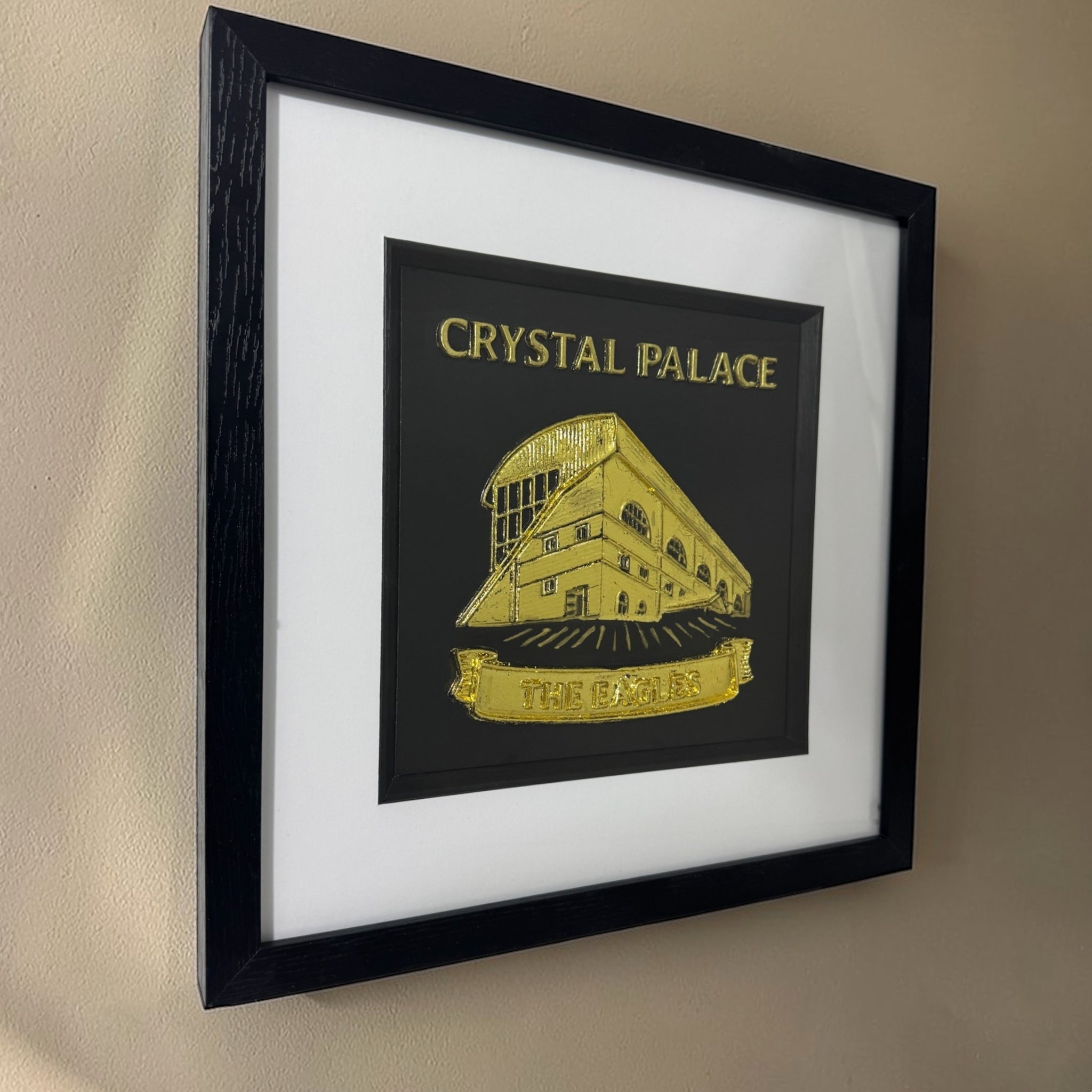 Gold Crystal Palace stadium 3D relief framed artwork on wall, angled side view showing frame depth and glass reflections