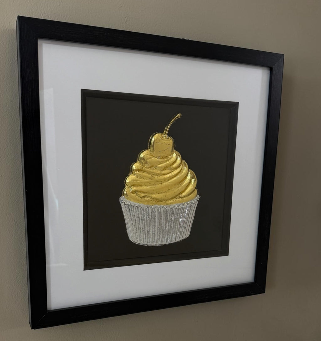 Angled cupcake framed artwork showing raised gold and silver relief detail through the glass front.