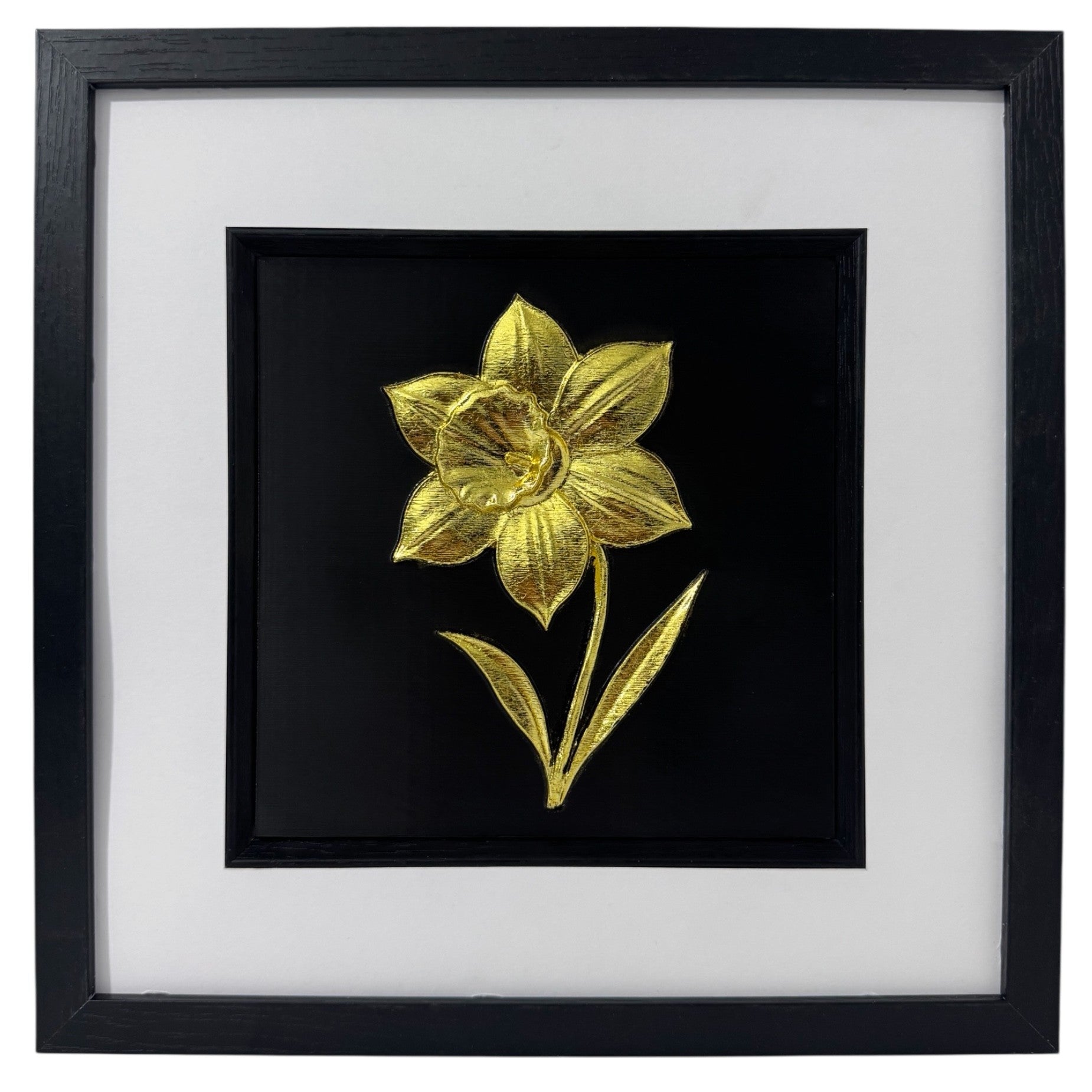 Gold daffodil wall decor in a black box frame with wide white mount and black inner surround.