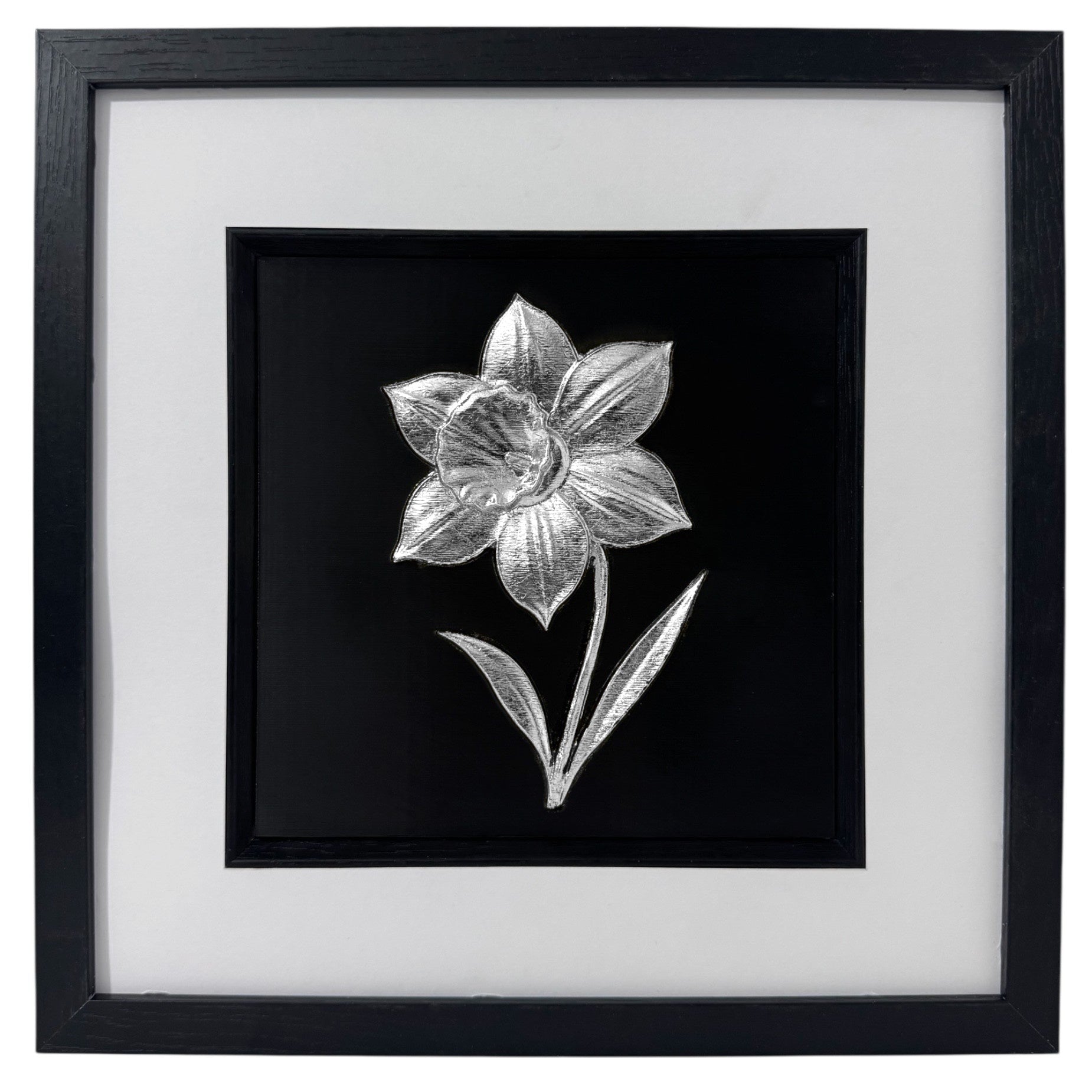 Silver daffodil relief in a black box frame with wide white mount and black inner surround.
