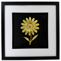 Gold daisy raised relief in a black frame with white mount and black inner surround on a white background.