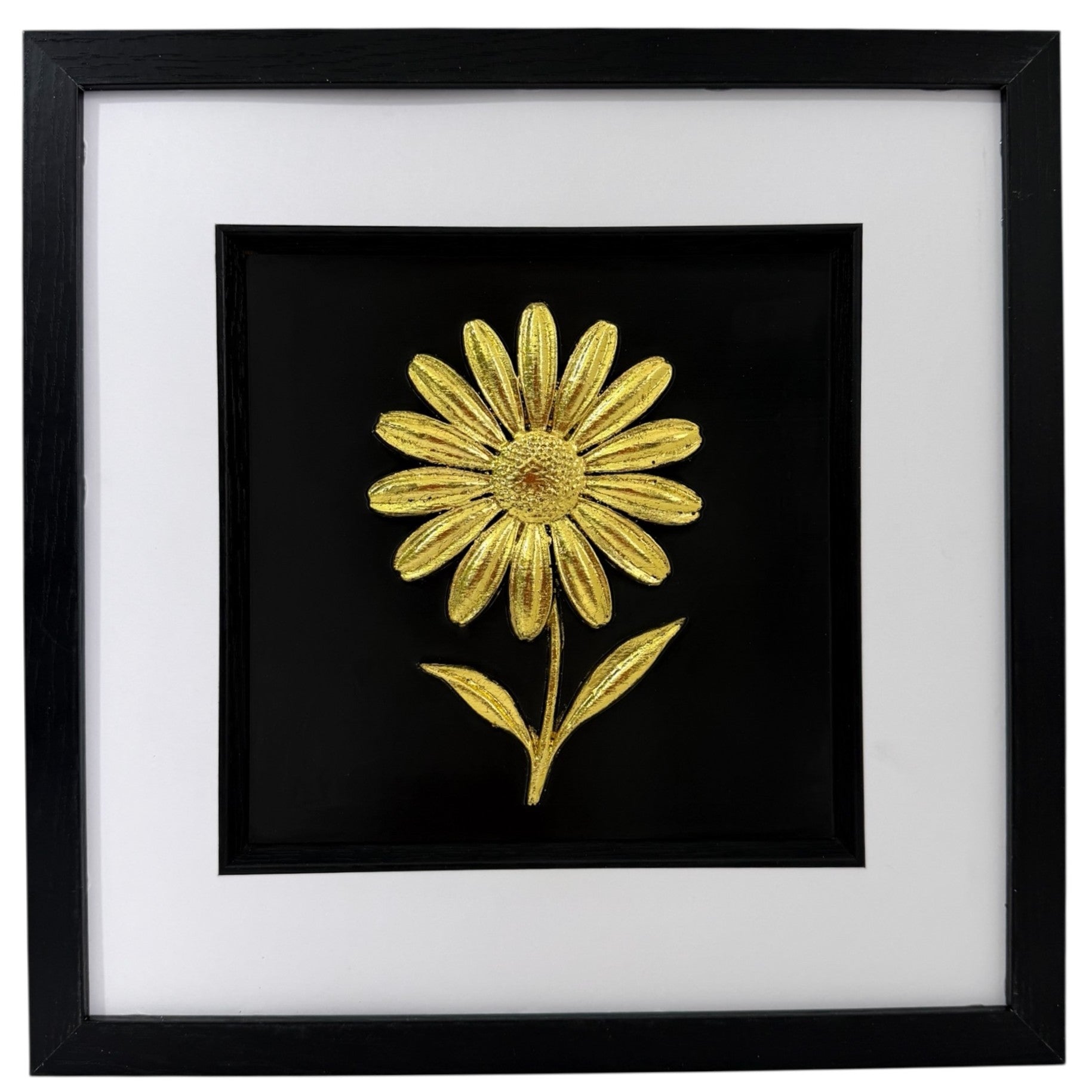 Gold daisy raised relief in a black frame with white mount and black inner surround on a white background.