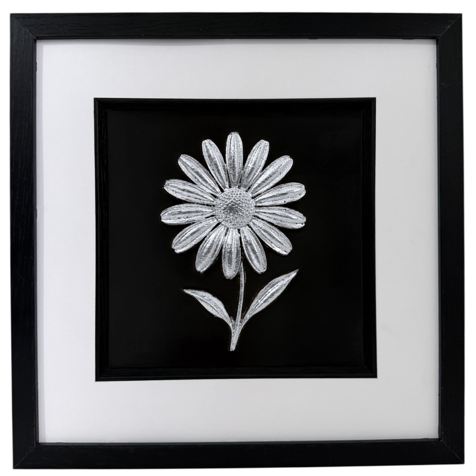 Silver daisy raised relief in a black frame with white mount and black inner surround on a white background.