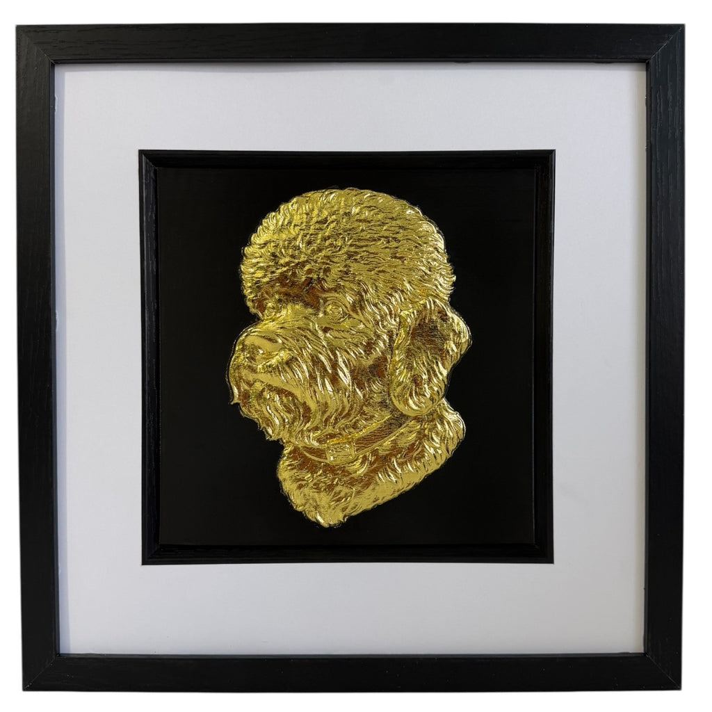 Front view of a gold Dandie Dinmont Terrier relief portrait in a square black frame with a wide white mount and black inner surround.