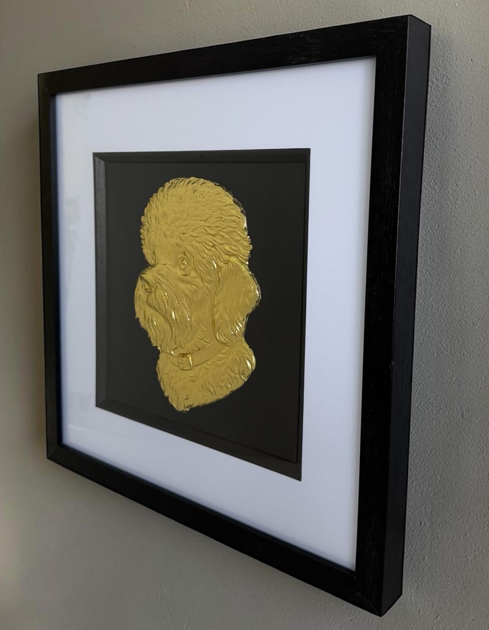 Gold Dandie Dinmont Terrier relief portrait hanging on a neutral wall in a square black frame with wide white mount and black inner surround.