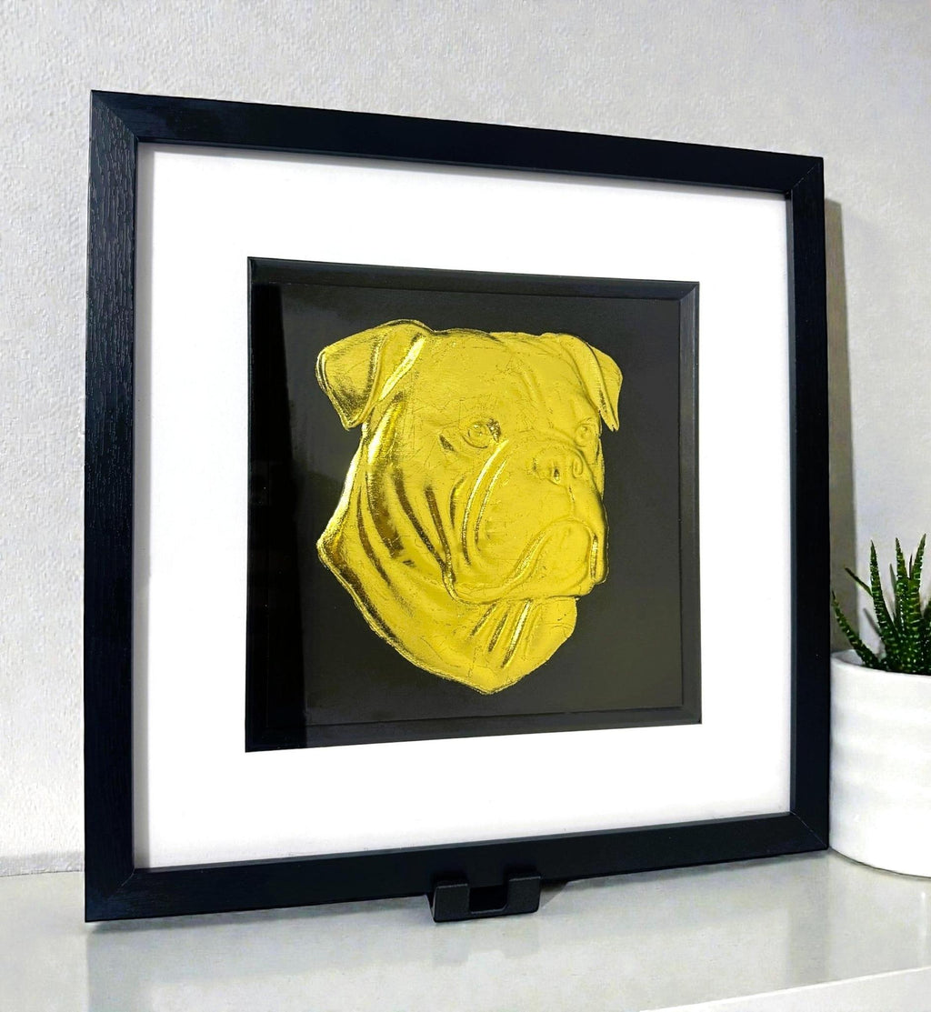 Black display stand holding framed wall art on a desk