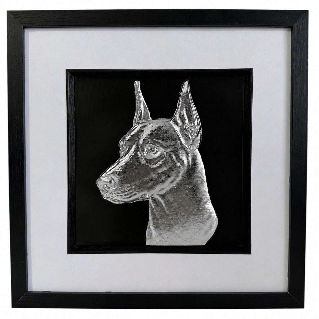Front view of a silver doberman relief portrait in a square black frame with wide white mount and black inner surround.
