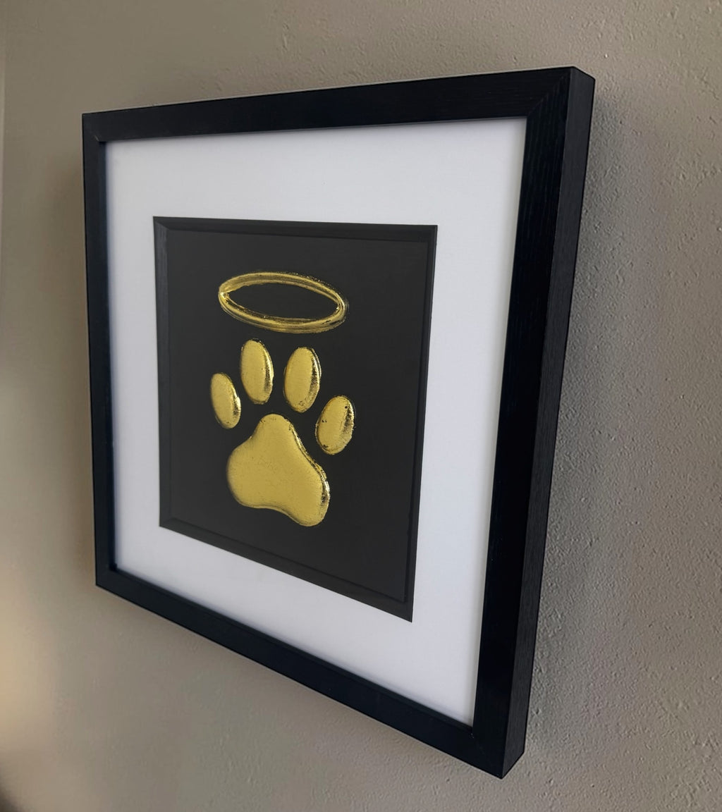 Close-up of raised dog paw print with halo memorial finished in gold leaf
