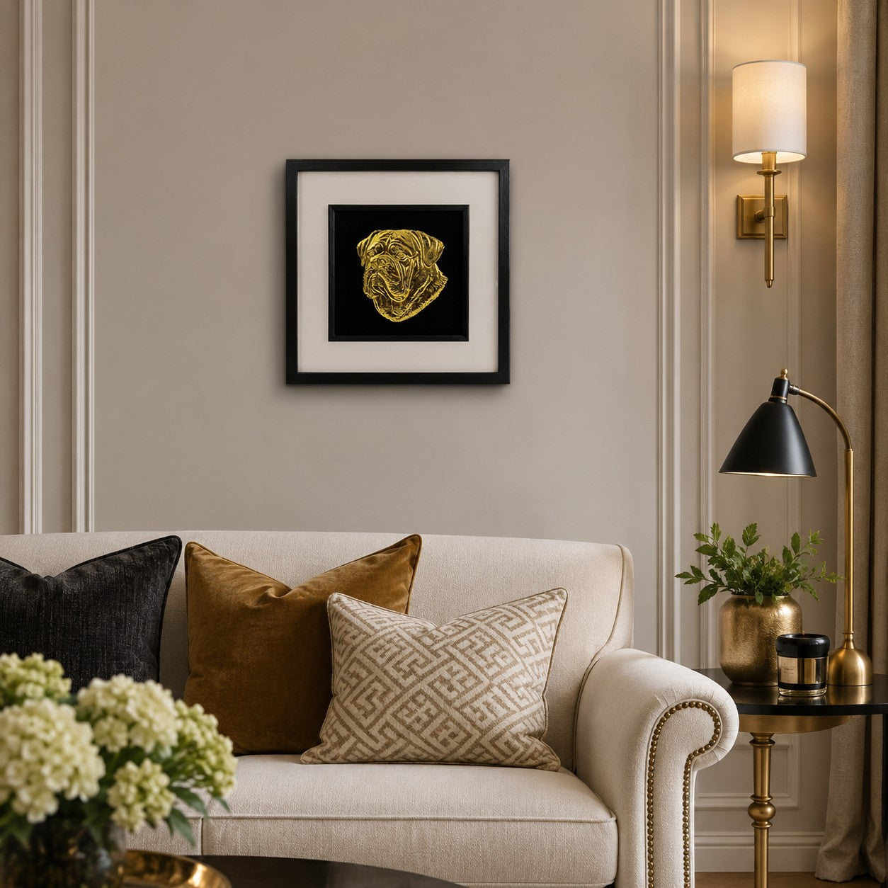 Dogue de Bordeaux gold leaf framed dog wall art displayed above a cream sofa in a warm neutral living room with black and gold accents.