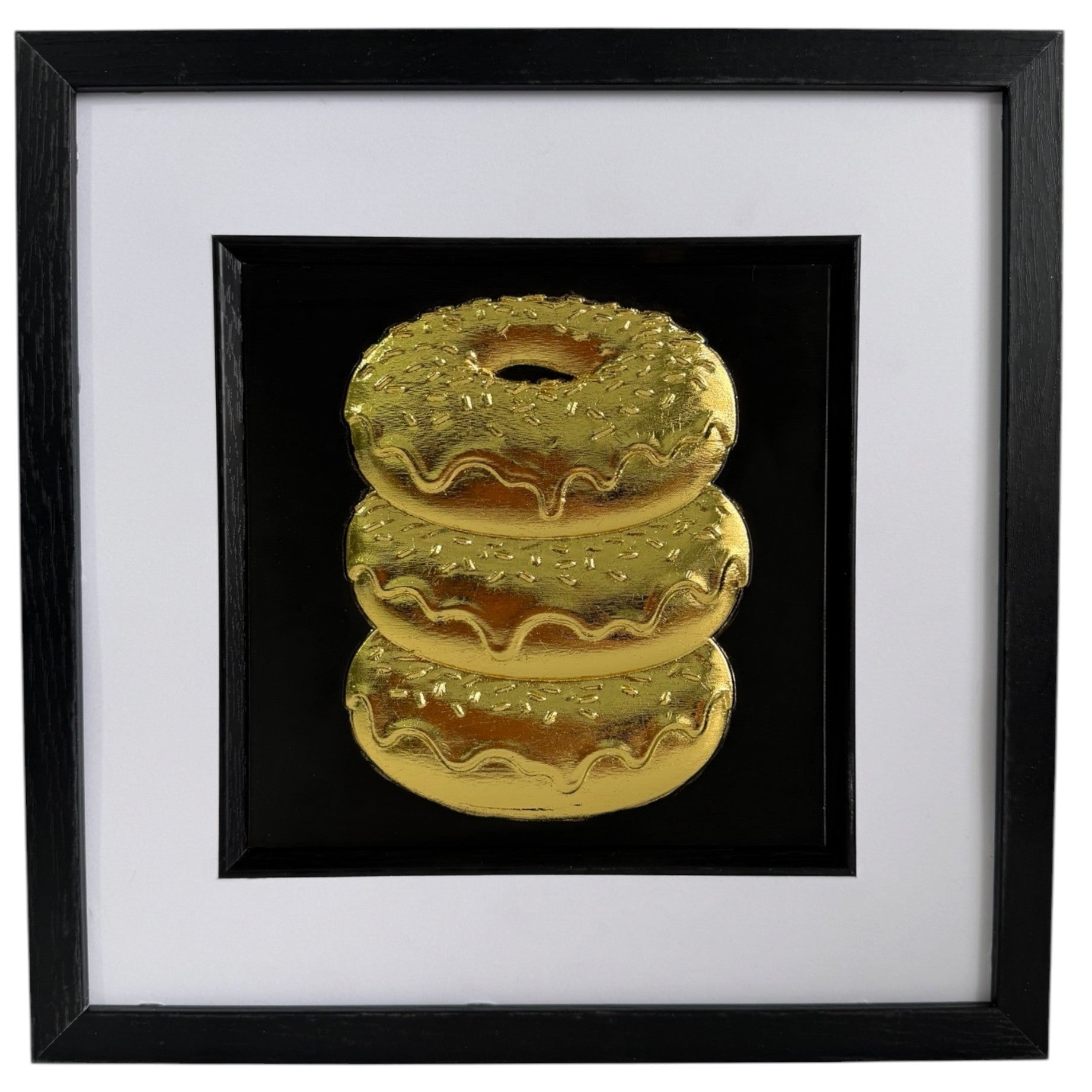 Straight-on Gold doughnut stack relief artwork with black centre panel, white mount and black frame.