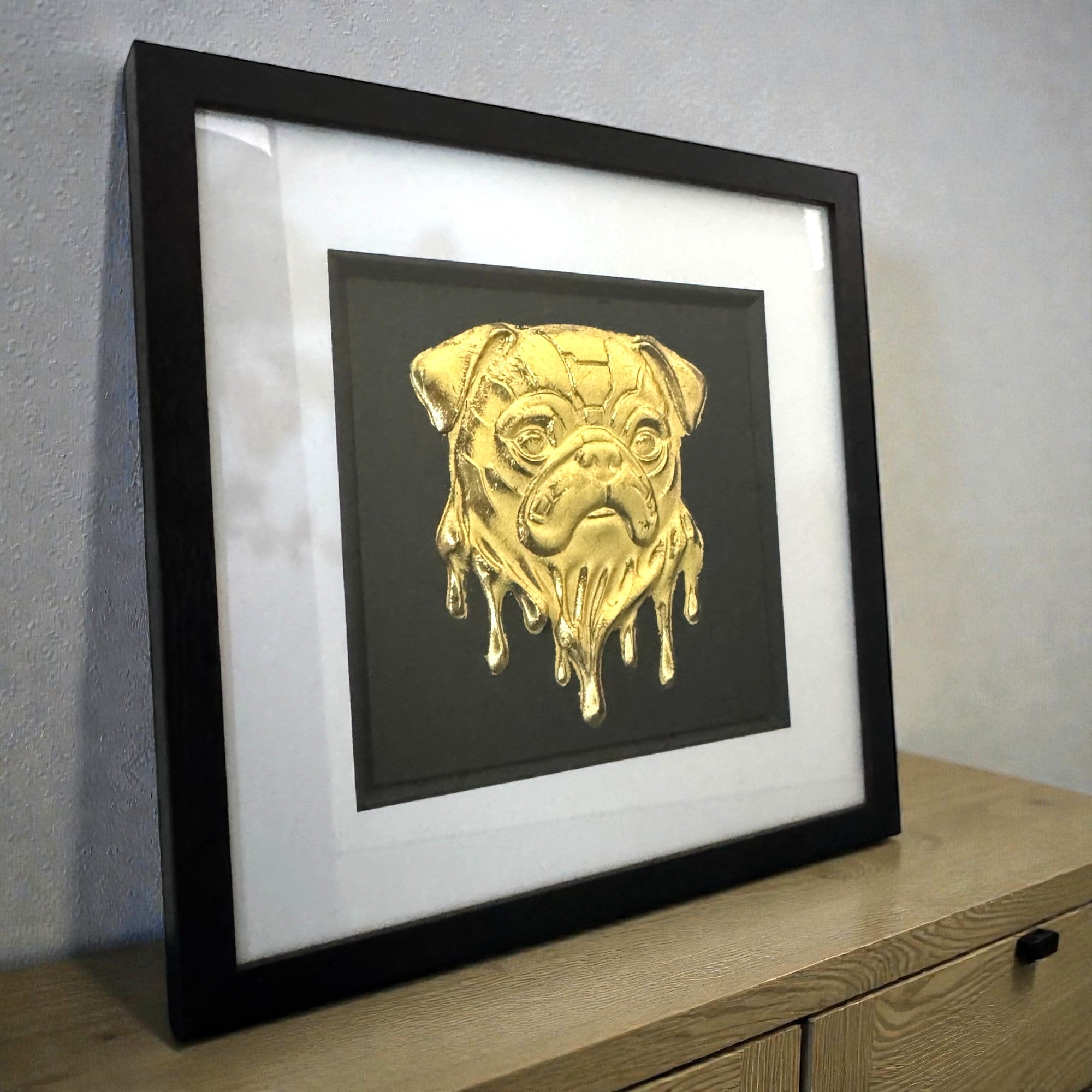 Molten Dripping gold effect pug portrait frame and set on a wooden side board in a modern interior
