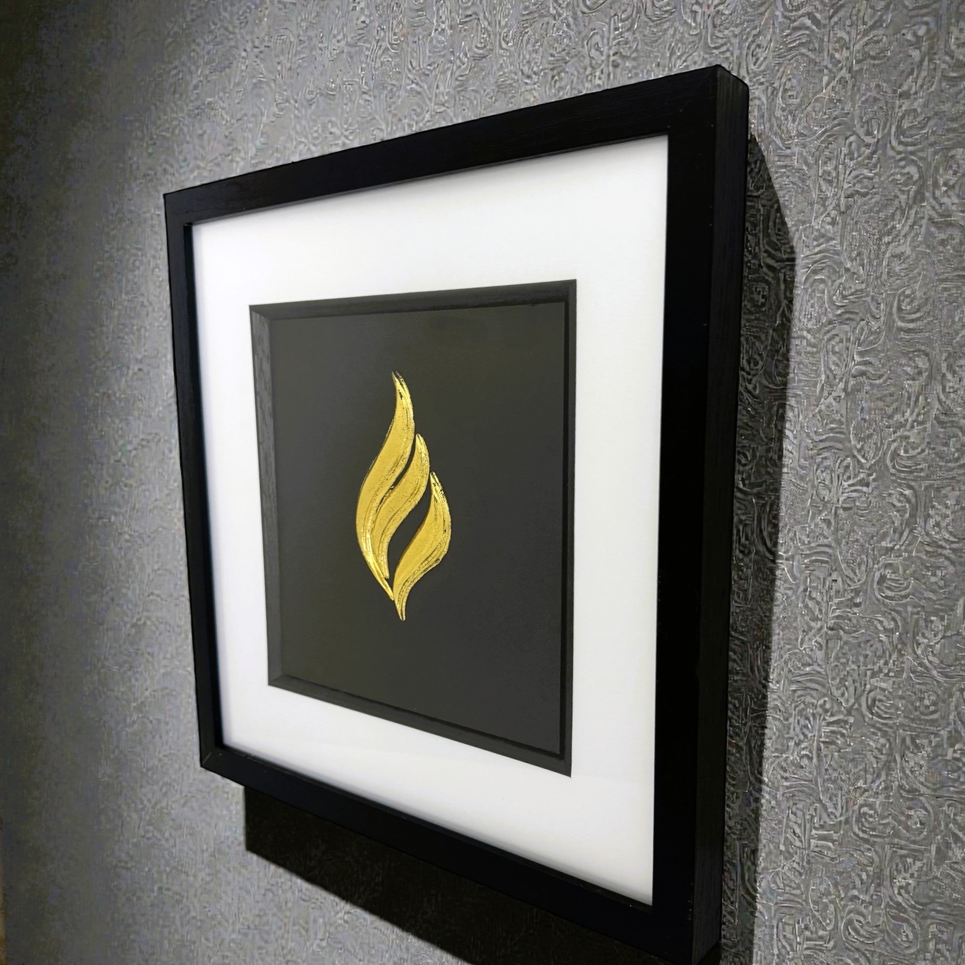Eternal flame gold leaf wall art displayed on a wall in a black frame with white mount