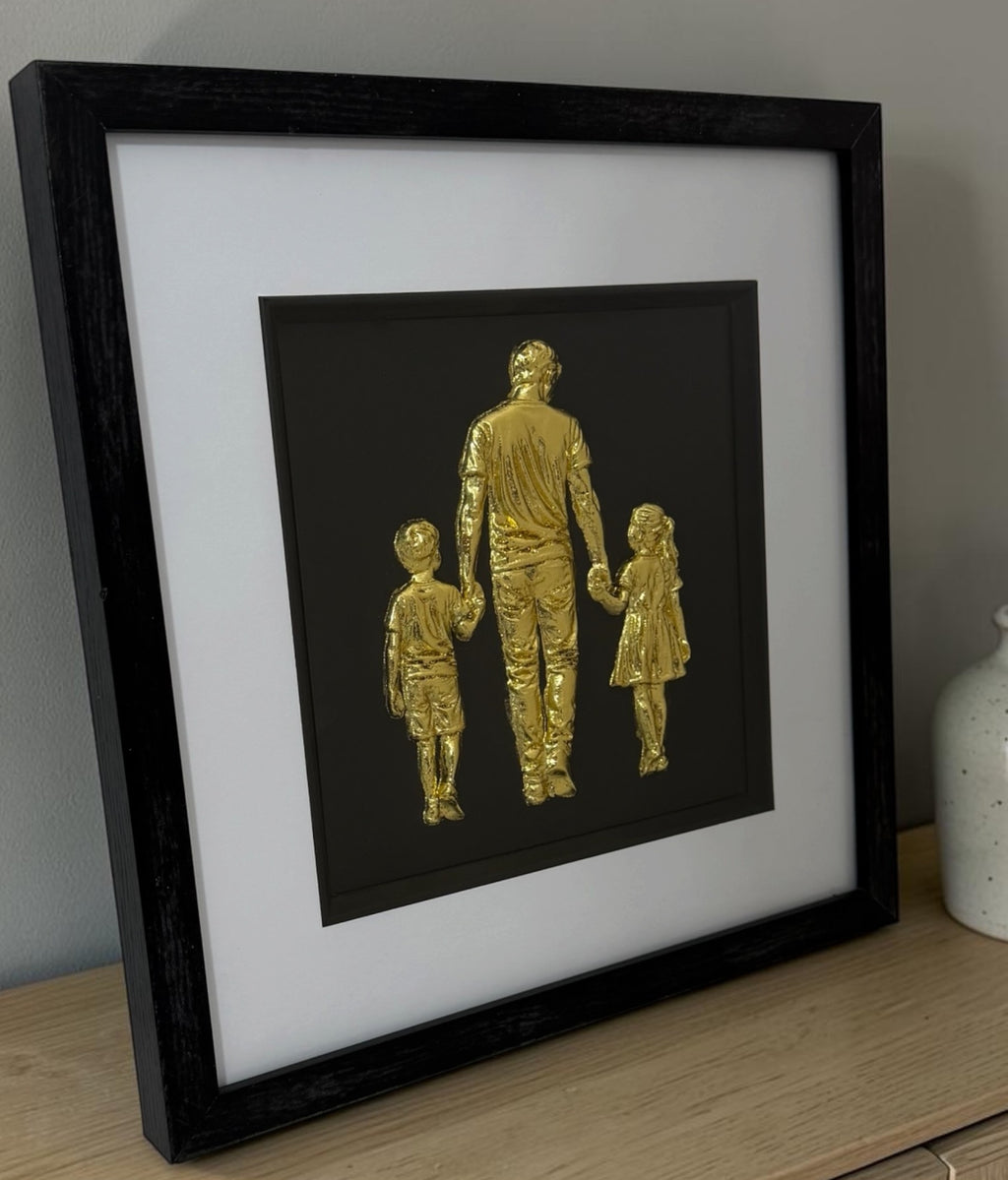 Gold family framed 3D artwork on a sideboard showing black box frame depth and raised detail.