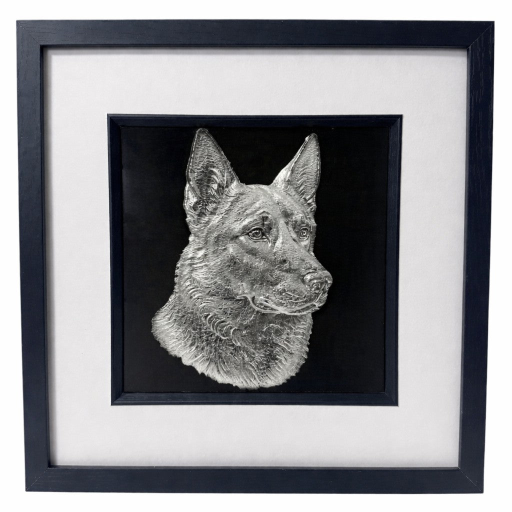 German Shepherd framed wall art showing a sculpted dog portrait in silver leaf, set on a black background with white mount and black wooden frame
