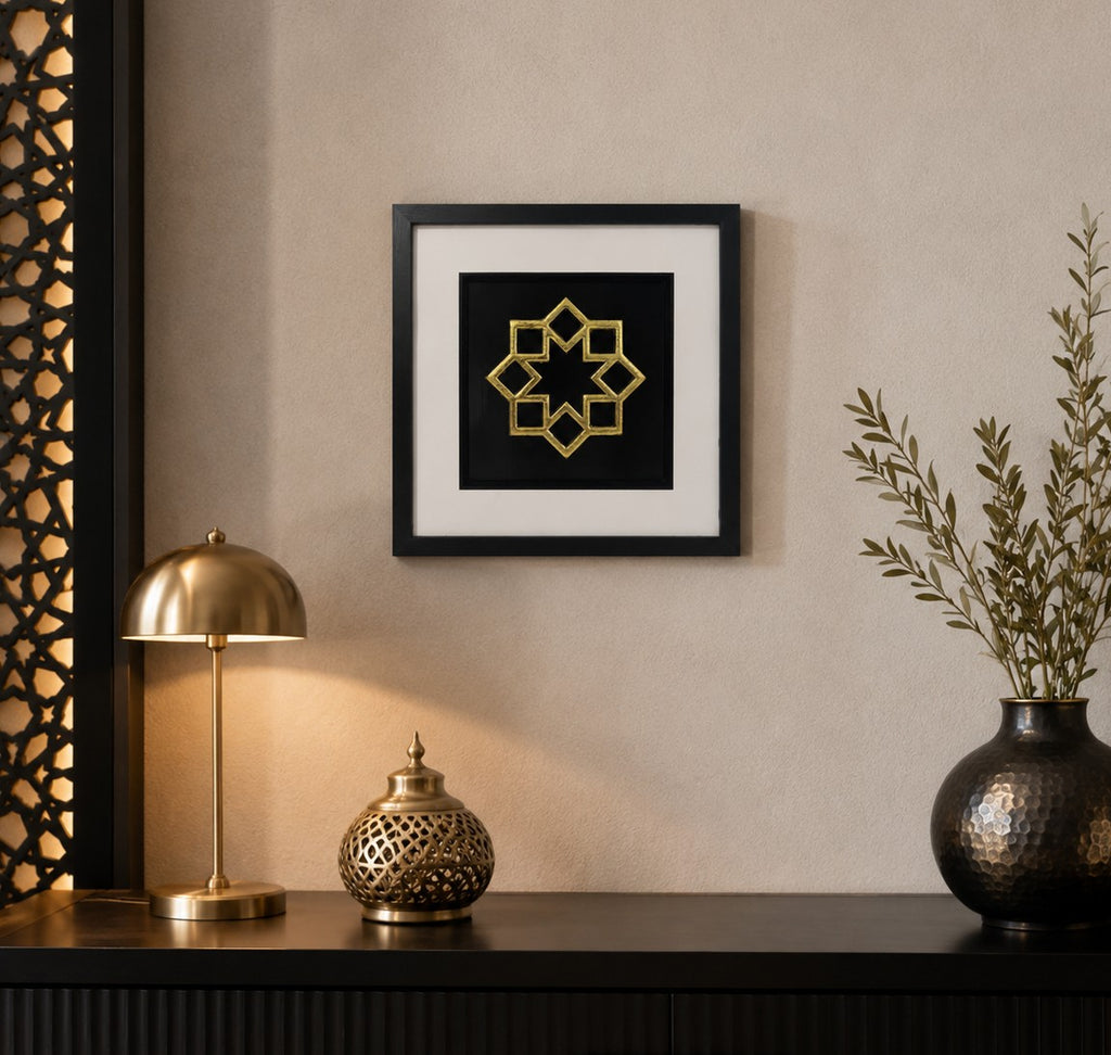 Framed gold 8 point Islamic star wall art on a black background, styled in a warm modern home interior with black and gold decor accents.