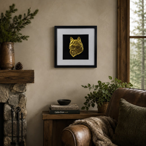 Gold Akita dog portrait 3D wall art in a black frame displayed on a warm neutral living room wall with rustic wood, stone, greenery and cosy cabin decor.