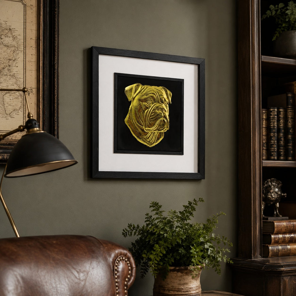 Angled lifestyle view of gold American Bulldog framed wall art hung on a green study wall with leather seating, wood shelving and elegant home decor.