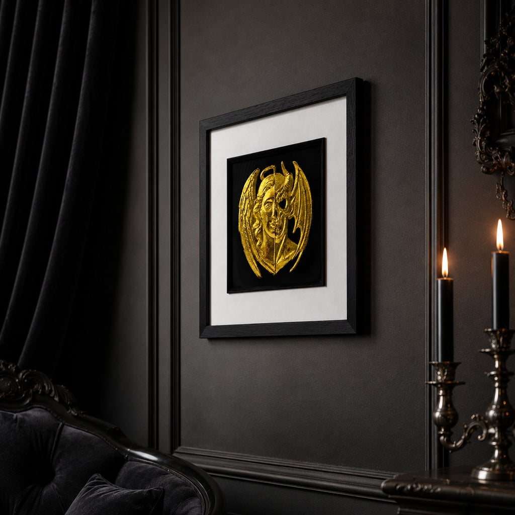 Angled view of framed gold angel and demon gothic 3D wall art on a dark wall with black frame, white mount and moody candlelit decor.