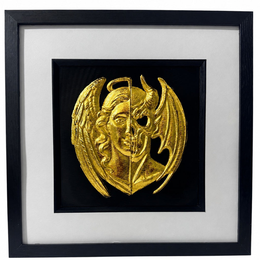 Framed gold angel and demon gothic 3D wall art with split face design, black background, white mount and black frame.