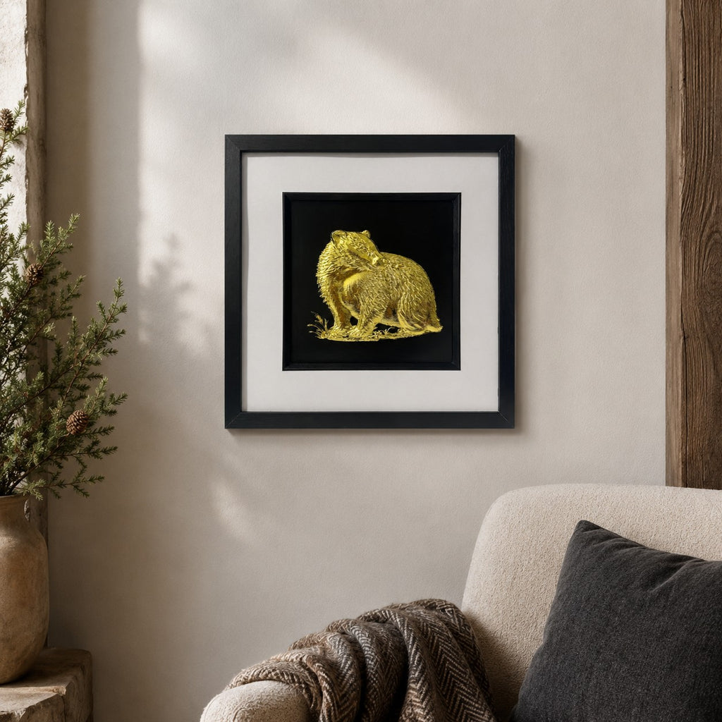 Gold badger 3D wall art in a black square frame with white mount, styled on a neutral wall in a warm woodland-inspired living room setting.