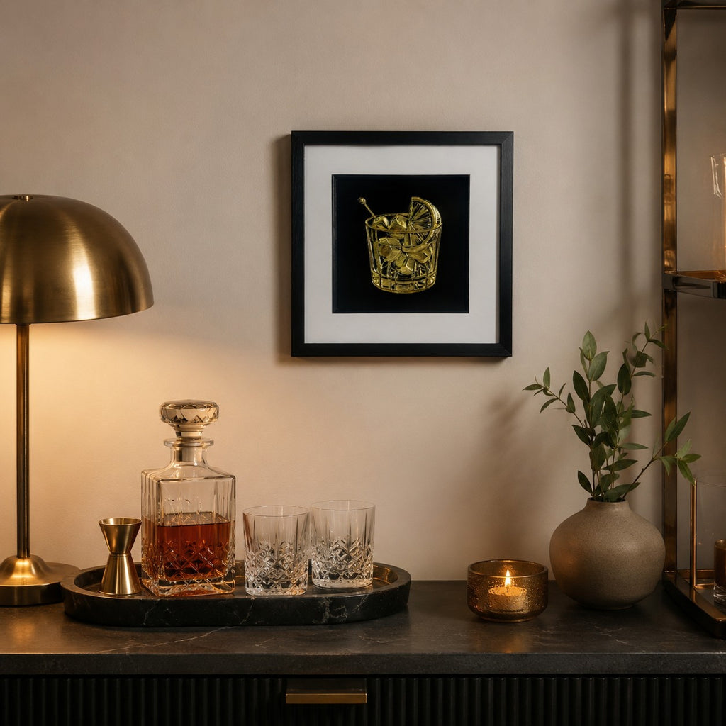 Gold cocktail wall art displayed in a stylish home bar setting, featuring a framed hand gilded gold leaf 3D relief cocktail glass design on a black background with luxury bar decor.